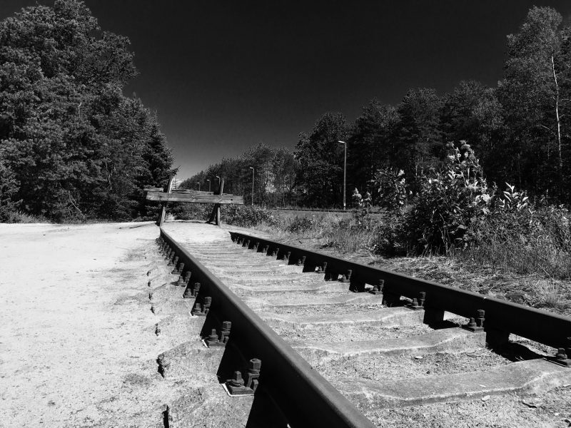 Black and white photo: train tracks at the end of the line